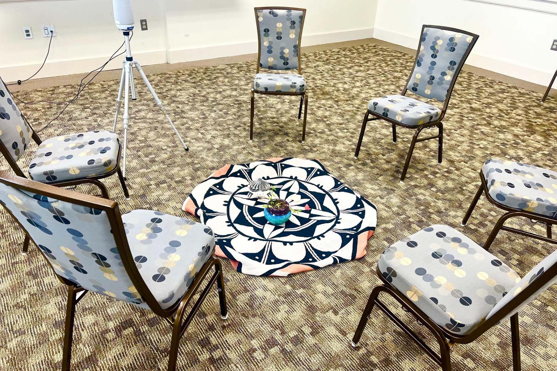 chairs arranged in a circle around a square mat