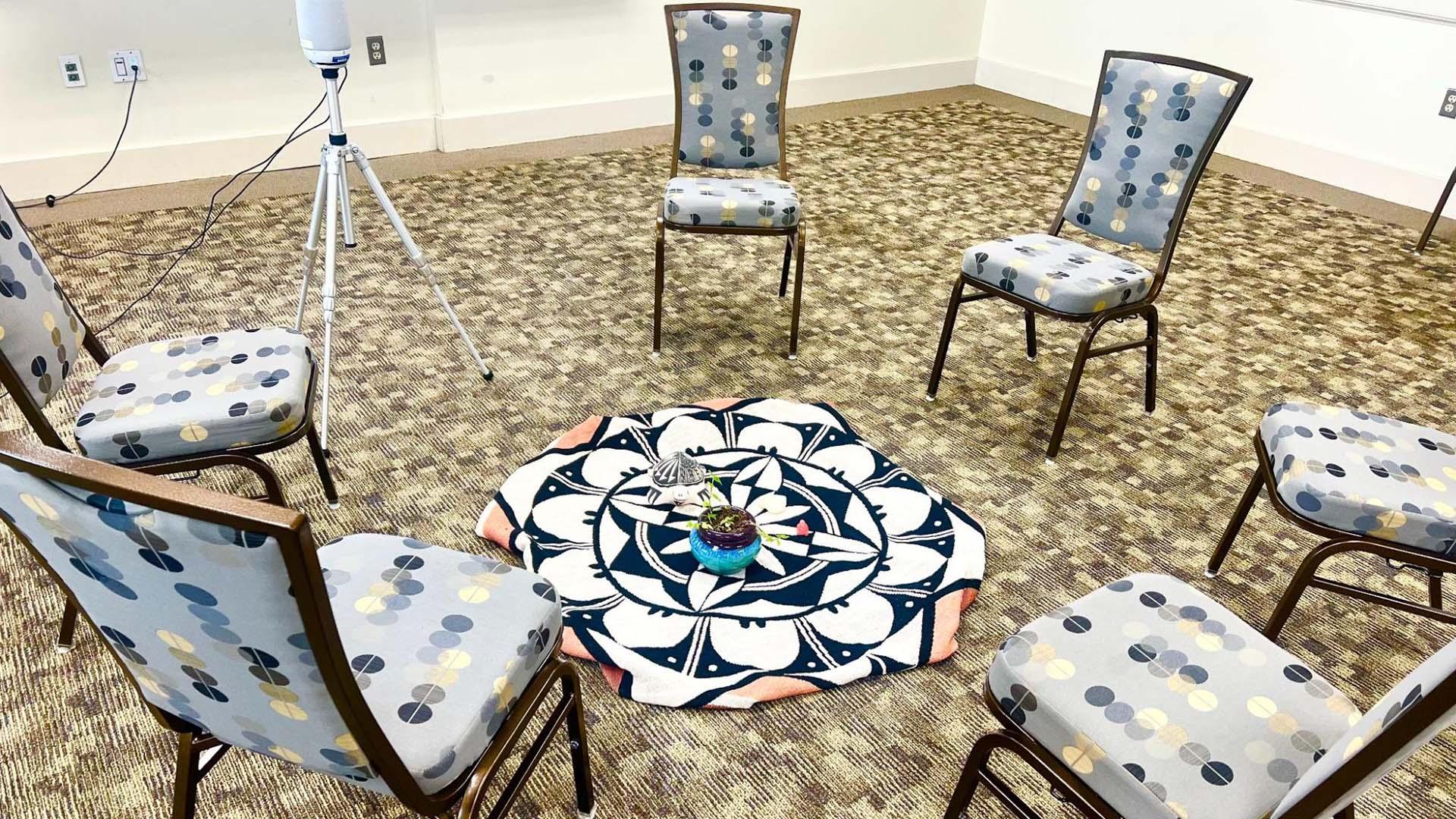 chairs arranged in a circle around a square mat